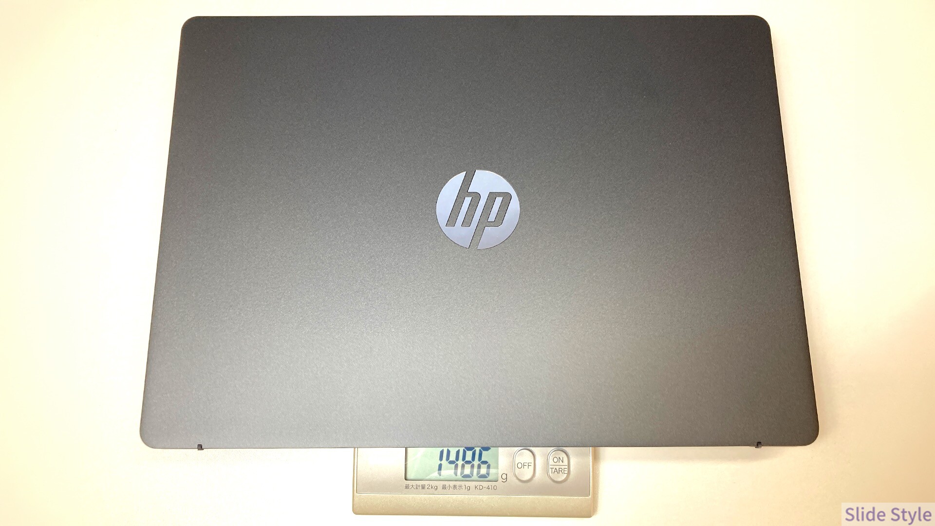 キッチンスケールに載せたHP OmniBook 3 14-hw。表示は1,486g